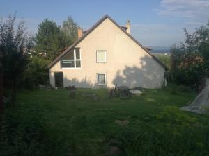 a white house in a field with a yard at privát femamki in Ličartovce