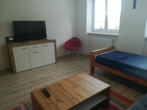 Cette chambre comprend un lit, une télévision et une table. dans l'établissement Pod Zámkom, à Kremnica