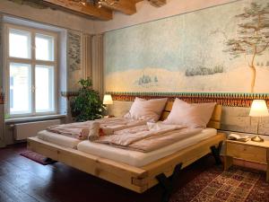 普日博爾的住宿－Lucerna - dům s duší Příbor，卧室配有一张大床,墙上挂有绘画作品