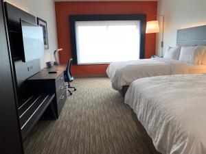 a bedroom with a bed and a television at Holiday Inn Express & Suites - Aurora Medical Campus, an IHG Hotel in Aurora