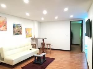 a living room with a white couch and a table at Apartamentos Paipa in Paipa