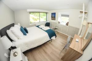 een slaapkamer met een groot bed met blauwe en witte kussens bij VIMY@Home in Vimy