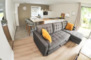 a living room with a couch and a kitchen at VIMY@Home in Vimy