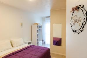 a bedroom with a bed and a sign on a wall at Pousada das Flores UpSerra in Urubici