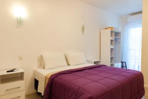 um quarto com uma cama com um cobertor roxo em Pousada das Flores UpSerra em Urubici
