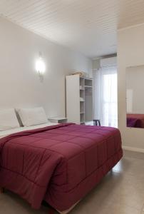 - une chambre avec un grand lit et une couverture rouge dans l'établissement Pousada das Flores UpSerra, à Urubici