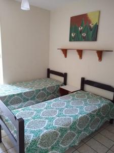 ein Schlafzimmer mit 2 Betten und einem Wandgemälde in der Unterkunft 1 quarto 2 camas de solteiro in Guarapari