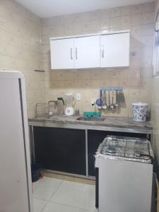 eine Küche mit einer Spüle und einer Arbeitsplatte in der Unterkunft 1 quarto 2 camas de solteiro in Guarapari
