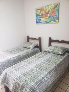 2 Betten nebeneinander in einem Zimmer in der Unterkunft 1 quarto 2 camas de solteiro in Guarapari