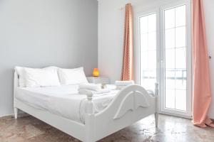 纳克索乔拉gatis house的一间白色的卧室，配有一张白色的床和一扇窗户
