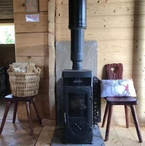 a wood stove in a room with two chairs at Mazot Hirondelle in Morzine