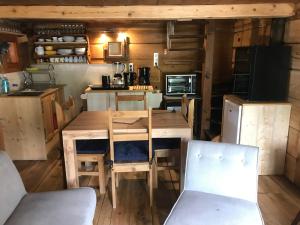 een keuken met een houten tafel en stoelen bij Mazot Hirondelle in Morzine