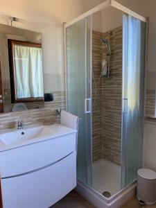 uma casa de banho com um chuveiro, um lavatório e um chuveiro em La casetta em Orte