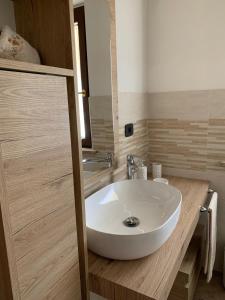 W łazience znajduje się biała umywalka i lustro. w obiekcie La casetta w mieście Orte