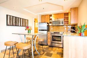 een keuken met een aanrecht en een tafel met krukken bij Sundial Hotel in Whistler