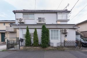 Kokuryō的住宿－Setagaya-ku - House / Vacation STAY 4789，前面有树木的白色房子