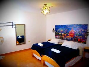 サンミゲル・デ・アジェンデにあるラ カトリーナ ホステルのベッドルーム1室(壁に絵画が描かれたベッド1台付)