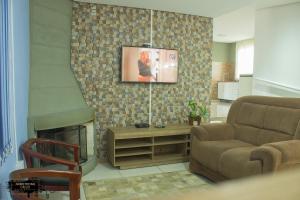 Una sala de estar con un sofá y una chimenea. en Pousada Da Campanha, en Bagé
