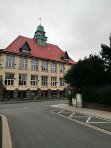 um grande edifício com um telhado vermelho numa rua em Ferienwohnung bei den Externsteinen em Horn-Bad Meinberg