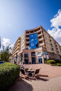 un edificio con sedie e tavoli di fronte ad esso di Green Kabaty Apartment 3 a Varsavia