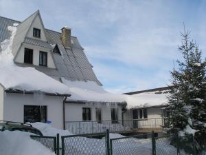 una casa ricoperta di neve con una recinzione di Pokoje Gościnne Irena a Bukowina Tatrzańska