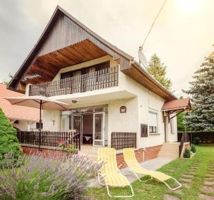 two yellow chairs in the yard of a house at Erika Apartmanház in Dombóvár