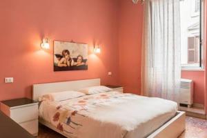ローマにあるFrattina De Luxeのオレンジ色の壁のベッドルーム1室、ベッド1台、窓が備わります。