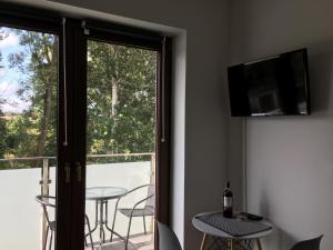 um quarto com uma varanda com uma televisão e uma mesa em Studio Fibra Lungo em Rybnik