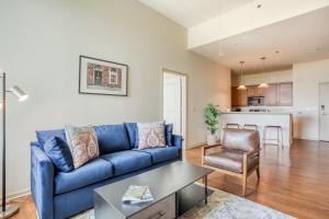 a living room with a blue couch and a chair at Mint House Greenville Downtown By Kasa in Greenville