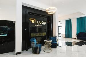 um átrio com cadeiras azuis e uma parede preta em Beluga Hotel em Atyraū
