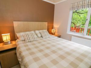 a bedroom with a bed with two lamps on night stands at Willow Lodge in Windermere