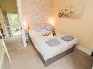 a bedroom with a bed with a tray of food on it at Pheasant Cottage in Whitby