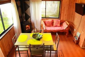 a living room with a table and a couch at Cabanas L'ESCALE in Coñaripe
