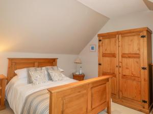 a bedroom with a bed and a wooden cabinet at 61 Seatown in Buckie