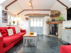 a living room with a red couch and a fireplace at Meadowview Cottage in Launceston