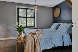 a bedroom with a blue bed and a window at Logement 1818 in Bakel