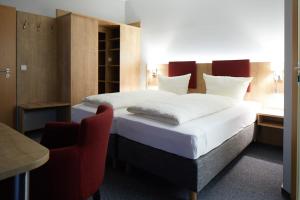 オーバーアスバッハにあるGasthof Pension Kettlerのベッドルーム1室(大型ベッド1台、赤い椅子付)
