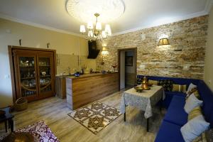 a living room with a blue couch and a kitchen at Hotel Daisy S Home in Kutaisi