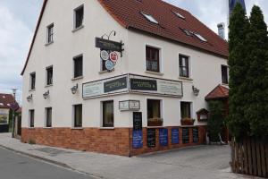 a white building with a clock on the side of it at Gasthof Pension Kettler in Oberasbach
