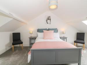 1 dormitorio con 1 cama y 2 sillas en Lyngaran House, en Holyhead
