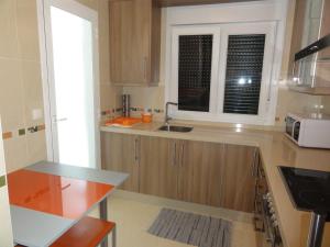 a kitchen with a sink and a window in it at Apartamento Playa Langosteira in Finisterre