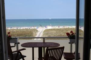 un tavolo e sedie su un balcone con vista sulla spiaggia di Residenz am Strande a Warnemünde