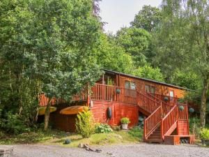 a cabin in the woods with a large deck at Willow Lodge in Windermere