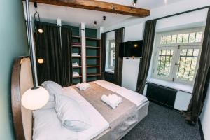1 dormitorio con 1 cama grande con almohadas blancas en Atoneli Apartment hotel, en Tiflis