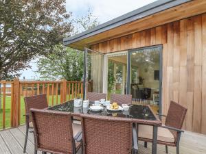 Un patio con una mesa y sillas en una terraza. en Elm, en Truro