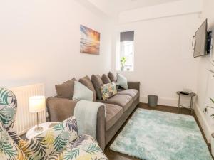 a living room with a couch and a rug at Lyngaran House in Holyhead