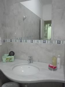 ein Badezimmer mit einem weißen Waschbecken und einem Spiegel in der Unterkunft Departamentos La Tita in Concepción del Uruguay