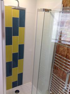 La salle de bains est pourvue d'une douche et de carrelage coloré. dans l'établissement Tivoli Place, à Marske-by-the-Sea