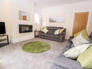 a living room with a couch and a tv at Park View in Llandudno