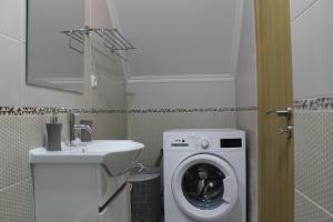 a bathroom with a washing machine and a sink at Apart Baía do Sado I in Setúbal